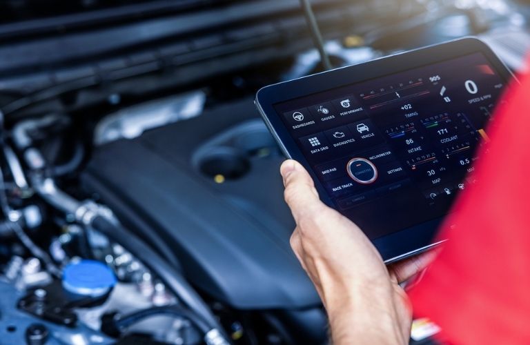 a technician holding a tab in front of a car