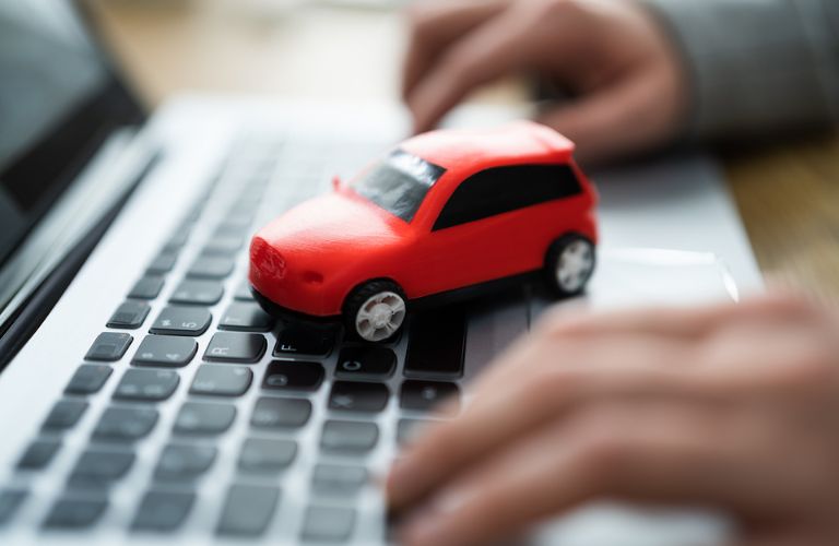 a toy car on a laptop's keyboard