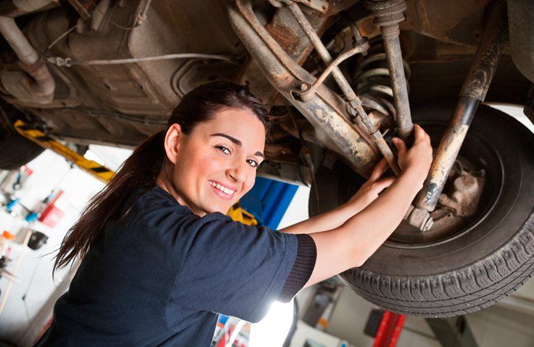 a technician working on the brakes of a car