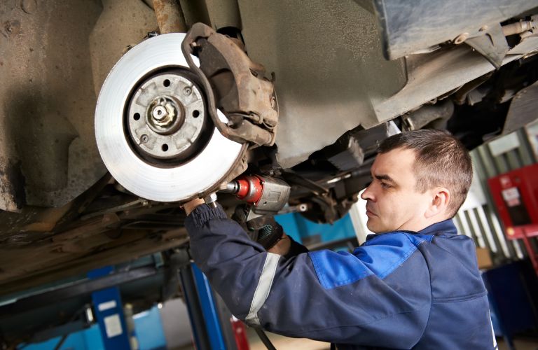 a mechanic checking the suspension of a car