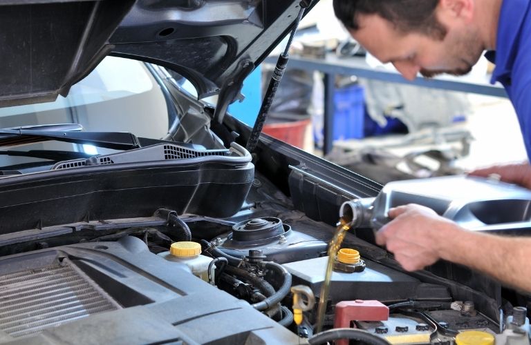 technician working under the hood of a car