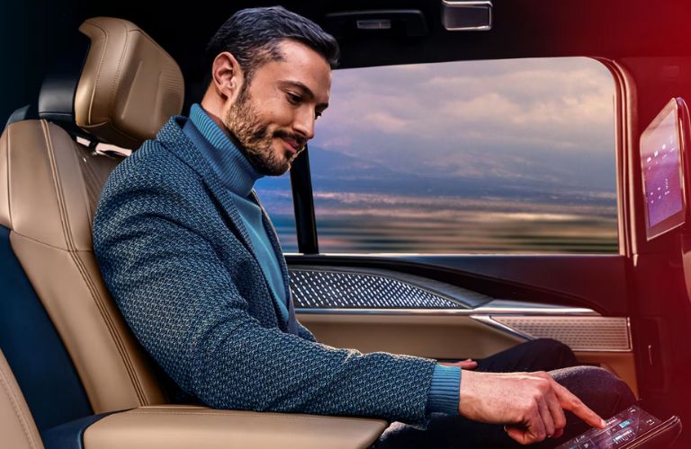 a man in the rear seat of the 2025 Cadillac Escalade IQ