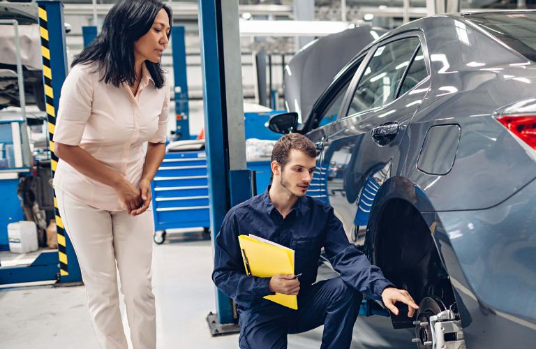 a woman and technician at a dealership's service center