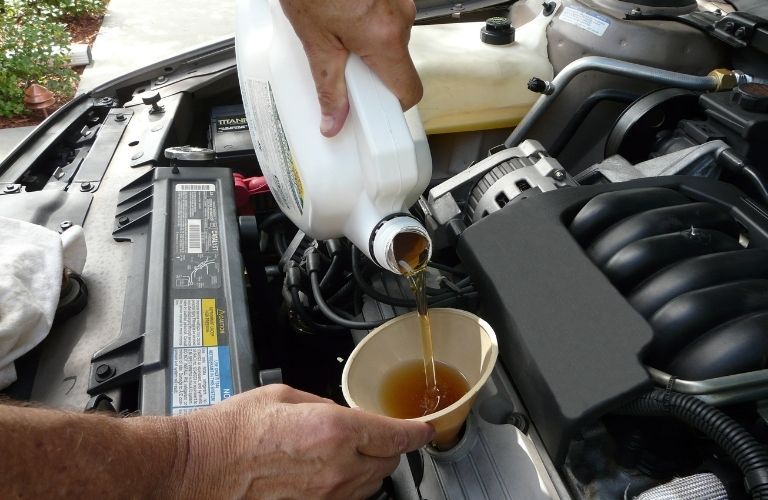 a technician changing oil in a car