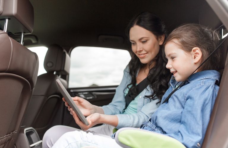 a mother and daughter in the back seat of a car